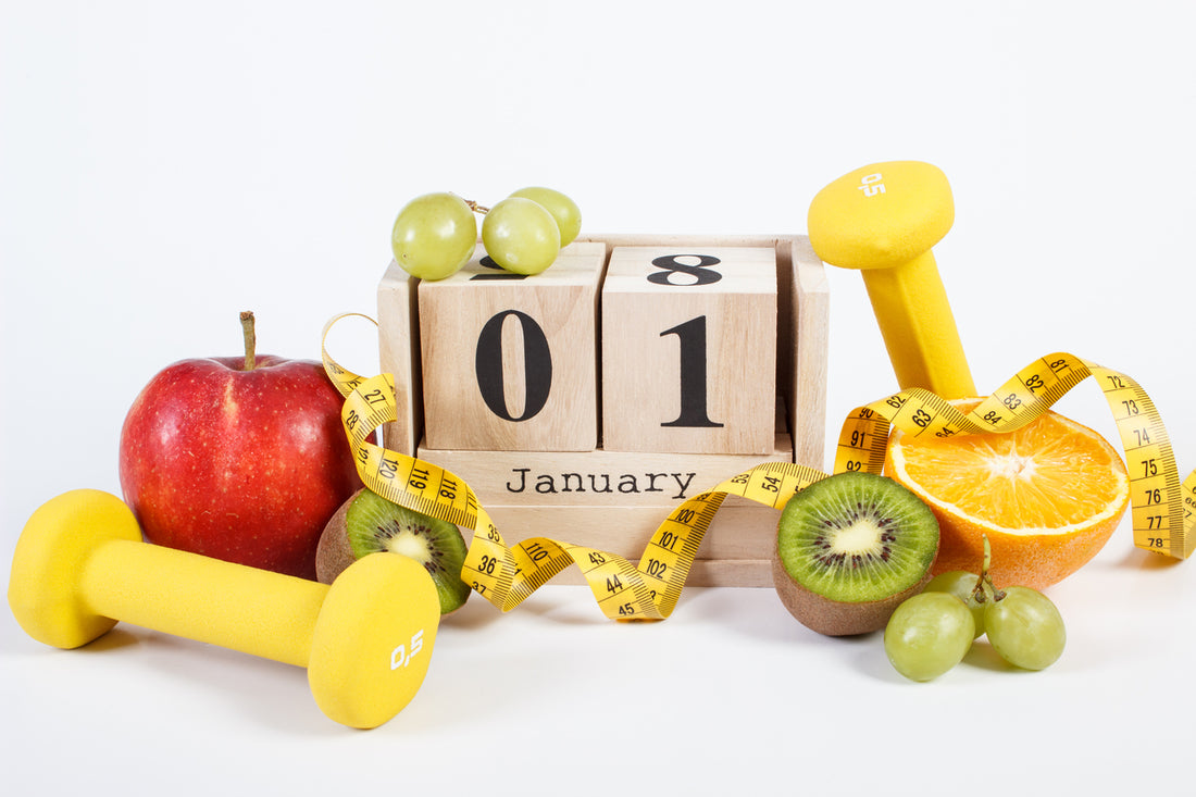 Start of the year on a cube calendar with dumbells, fruits, and measuring tape