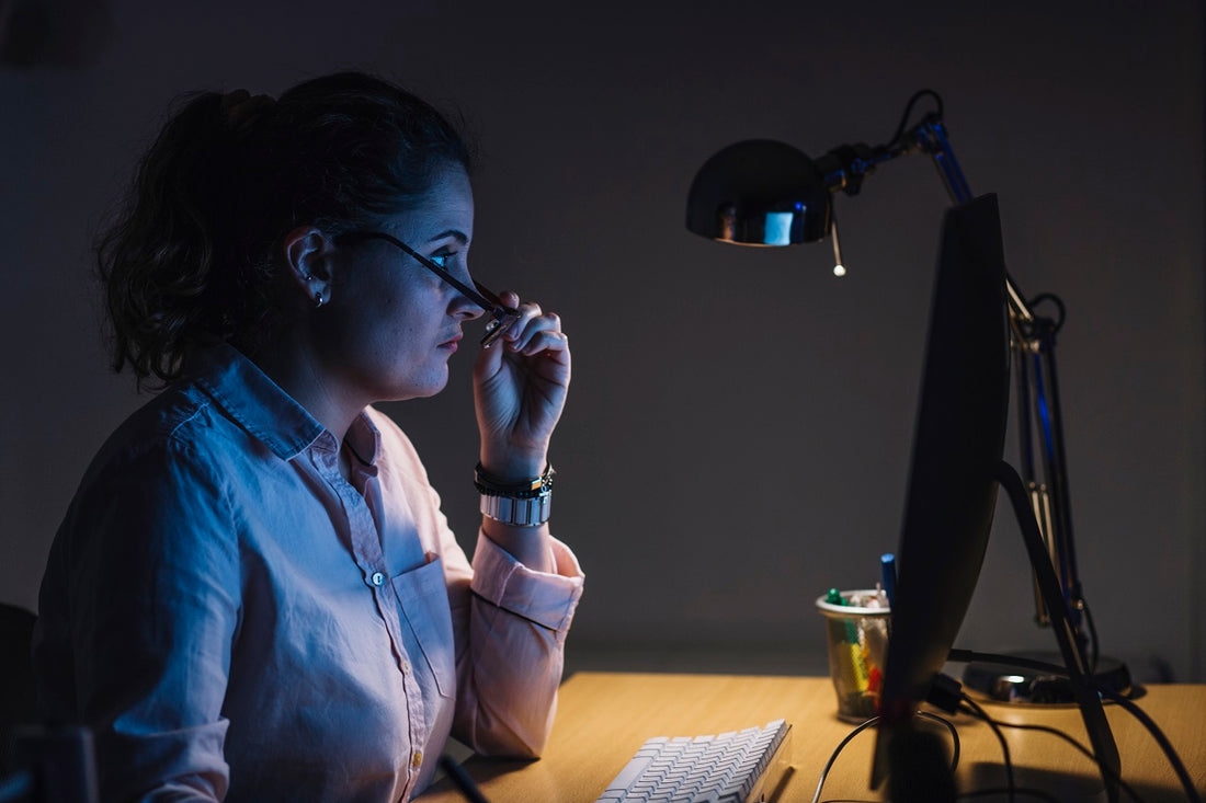 An adult woman working on her computer late at night