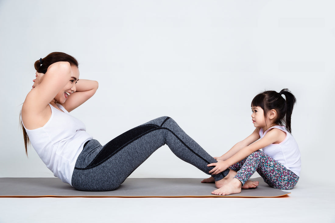 A mother doing sit-ups with her daughter